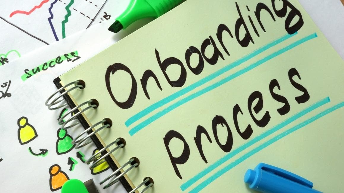 A notebook page with Onboarding Process written in marker, beside sketches and a pen