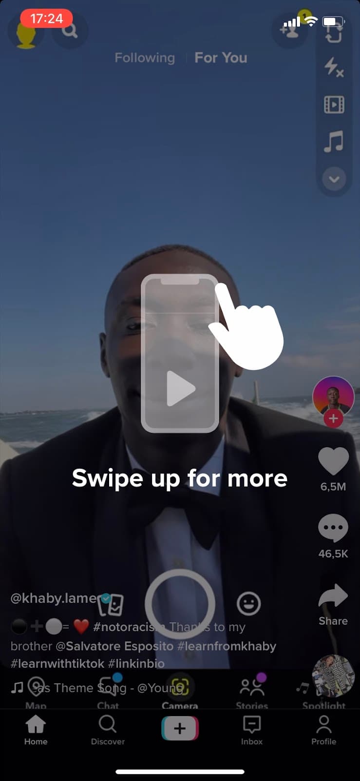 TikTok For You feed with a Swipe up for more overlay and a hand gesture over a playing video