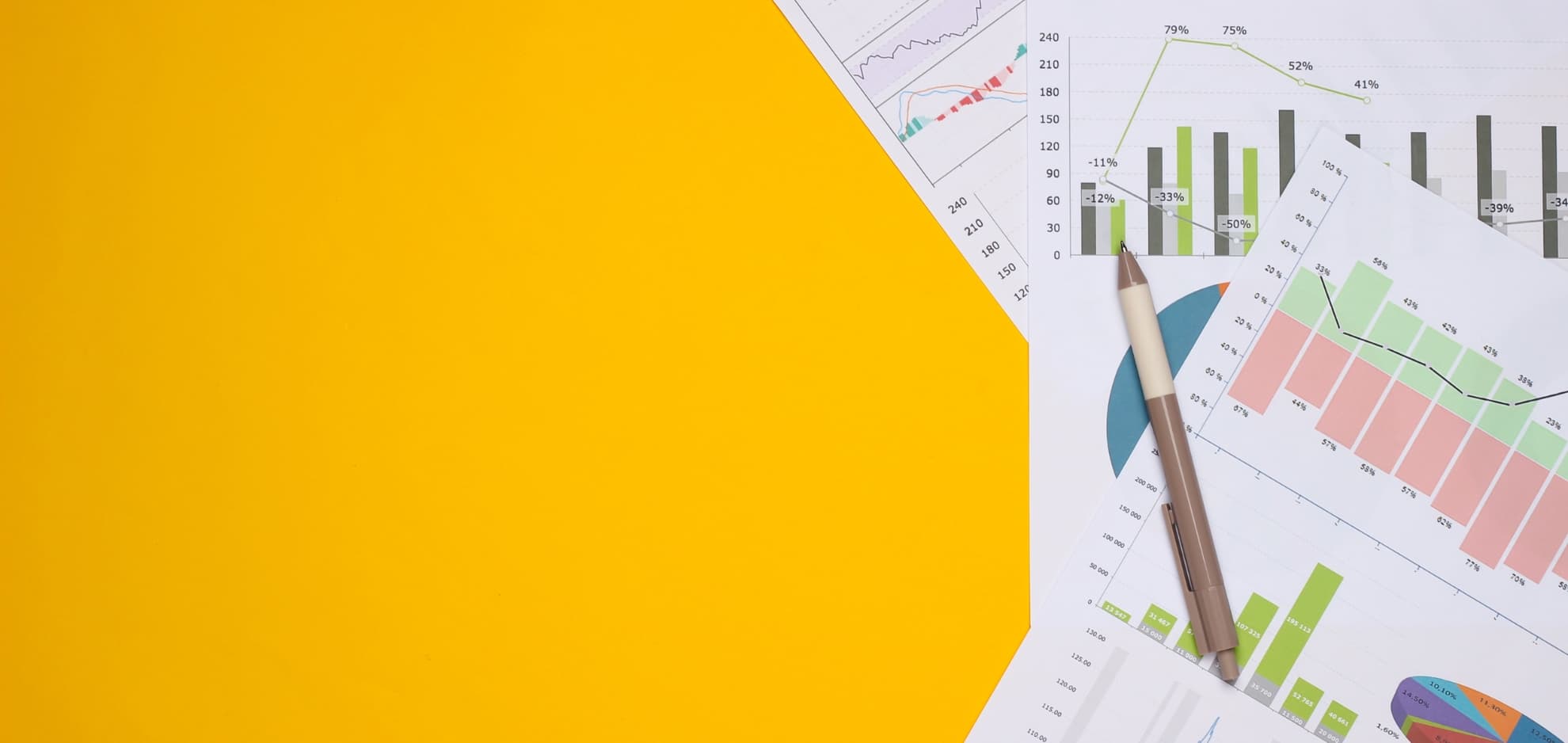 Printed charts and graphs with a pen on a yellow background
